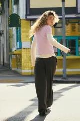 Pantalón de tiro medio con pinzas en el delantero, corte recto y amplio. Cuenta con trabillas en la cintura, bolsillos laterales y cierre frontal con cremallera, botón y gancho metálico.