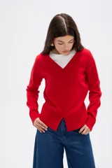 Cardigan de punto color natural, con escote en V profundo, cierre frontal con botones y mangas largas.