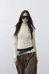 Polera de manga larga y cuello alto, confeccionada en tejido de punto fino con ajuste al cuerpo.