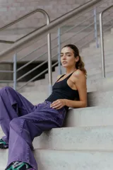 Jean de corte oversized y tiro medio-alto, confeccionado en denim de color violeta con diseño de cinco bolsillos y cierre frontal con botón y cremallera.