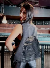 Chaleco sin mangas confeccionado en denim con efecto lavado y espalda de red transparente.