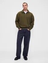 Buzo de estilo deportivo en color verde oliva, con cuello alto y cierre frontal parcial. Presenta mangas largas con puños elásticos y un corte holgado que brinda comodidad.