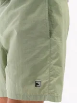 Short de baño negro de taslon de secado rápido, con moldería clásica, cintura elástica con cordón blanco para ajuste y un pequeño parche cuadrado con una letra 'F' en la parte inferior izquierda.