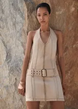 Vestido corto de algodón estilo denim, con diseño entallado, cuello halter y cierre frontal con cremallera. Incluye un cinturón decorativo integrado con hebilla metálica y costuras a la vista.