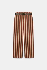 Pantalón de tiro alto y pernera recta con diseño de rayas verticales en tonos marrón, terracota y beige. Incluye bolsillos delanteros y un cinturón fino de color negro con hebilla metálica dorada. Cierre frontal con cremallera, botón interior y gancho.