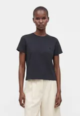 Remera de algodón color negro, con cuello redondo y diseño de corte clásico boxy ligeramente holgado.