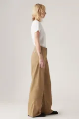 Pantalón chino color beige de corte ancho, con bolsillos laterales y traseros.