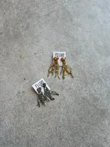 Par de aros colgantes irregulares hechos a mano en bronce y porcelana con mix de piedras y materiales para darle textura.