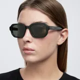 Lentes de sol con montura poligonal color verde oliva y lentes verdes polarizadas.