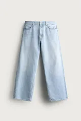 Jeans de denim de algodón en color azul con efecto desgastado, tiro medio y corte recto de ajuste holgado (loose fit). Cuenta con diseño clásico de cinco bolsillos y cierre frontal con cremallera y botón.
