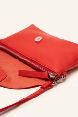 Cartera bandolera color beige, confeccionada en 100% cuero, con solapa redondeada, detalle de flor grabada y correa larga ajustable.