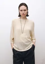 Jersey de punto fino en color beige, con diseño oversize, cuello redondo y mangas tres cuartos.