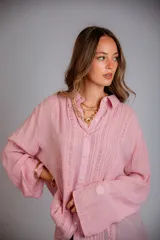 Camisa blanca de manga larga con detalle de bordados verticales en el frente y puños acampanados.