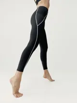 Legging largo negro de tejido Shape_Tech, con líneas de cinta reflectante en los laterales y bolsillos laterales.