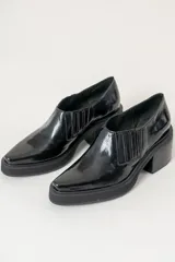 Botines negros de charol con elástico lateral, punta cuadrada y tacón bloque.