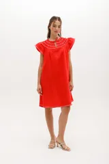 Vestido negro de lino, corte suelto, con cuello redondo con volados y mangas cortas con volados.