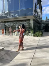 Vestido camisero midi con estampado animal print en tonos marrones y rojizos. Tiene cuello camisero, mangas largas con puños abotonados y lazo para ajustar en la cintura.