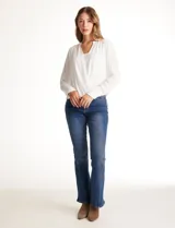 Blusa de gasa blanca, marca Catherine Malandrino, con cuello a la base y escote en V pronunciado. Incluye una pieza interna a tono para un escote discreto. Tiene manga larga con puño ancho y botón.