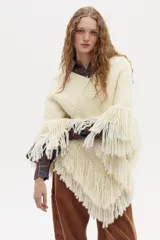 Poncho tejido en lana merino multicolor con escote en V y flecos decorativos en el ruedo.