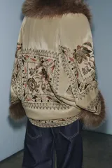 Kimono de la colección ZW de Zara, confeccionado en tejido satinado color beige con bordados intrincados, abalorios y aplicaciones de pelo sintético a contraste en cuello y puños.