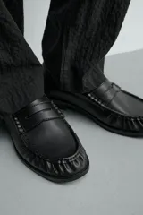 Mocasín de vestir para hombre en color marrón oscuro, con diseño clásico de antifaz en el empeine, detalle fruncido en la parte delantera y suela con ligero tacón.