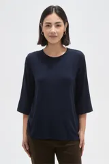 Remera de viscosa con textura acanalada, cuello redondo y mangas 3/4. Presenta un corte holgado y fluido.