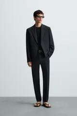 Blazer de corte regular fit confeccionado en tejido con lana. Presenta cuello con solapas de muesca, cierre frontal de dos botones, manga larga con puños abotonados, bolsillo de vivo en el pecho y bolsillos con solapa en la cadera.