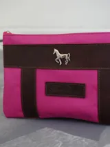 Sobre tipo cartuchera de lona naranja con detalles y apliques en cuero marrón. Presenta un aplique metálico en forma de caballo y un parche con el logo de la marca grabado en el frente.