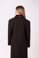 Tapado largo de paño color beige, con diseño de doble botonadura, solapas con detalle en contraste negro y bolsillos laterales con ribete negro.