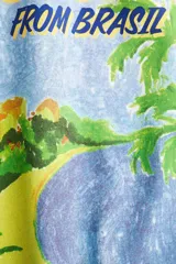 Remera blanca de manga corta y cuello redondo, con un estampado gráfico que simula una postal de Brasil, mostrando una playa tropical con palmeras y vegetación.