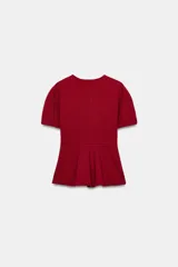 Top peplum confeccionado en hilatura de algodón de color bordó, con escote en V pronunciado, mangas cortas abullonadas y bajo con vuelo.
