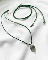 Gargantilla tipo choker con tiento de gamuza verde y dije de hoja plateada.