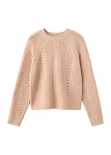 Jersey de punto trenzado color beige, con cuello redondo, manga larga y detalles de calados en el frente y las mangas.