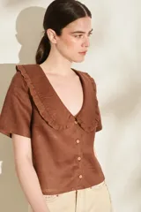 Blusa de lino color rojo, con mangas cortas, cuello en V con solapa redonda fruncida y cierre frontal de botones.