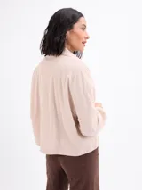 Campera de pana negra con cierre frontal de botones metálicos, cuello clásico y dos bolsillos frontales con solapa. Presenta mangas largas con puños abotonados y un diseño liviano sin forro.
