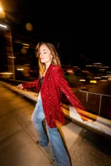 Blazer rojo de lentejuelas con solapas, corte recto y cierre de un botón.