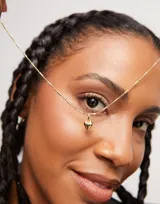 Dije charm con forma de corazón, bañado en oro de 18k.