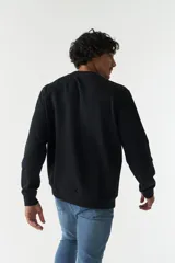 Buzo negro de felpa con cuello redondo y lettering estampado en el frente con la frase 'Always Grateful' y la marca 'Mistral'.