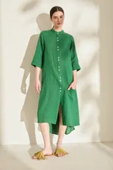 Túnica midi verde con cuello mao, botonadura frontal completa, mangas tres cuartos y bolsillo aplicado en el frente.