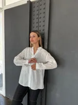 Camisa blanca de mangas largas con bordados florales.