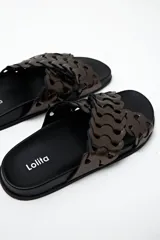 Sandalias chatitas de cuero color peltre con diseño calado y base negra.