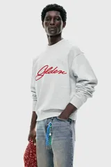 Buzo de cuello redondo en tejido de algodón gris melange, con diseño de hombros caídos y bordado frontal con la palabra 'Golden' en color rojo. Presenta puños y bajo acanalados.