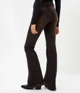Pantalón de jean corte flare con lavado sobretinta en tono marrón oscuro. Presenta cintura media con trabillas, cierre frontal con cremallera y botón, cinco bolsillos funcionales y ruedo deshilachado.
