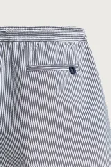 Short de baño confeccionado en tejido técnico con patrón de rayas verticales en tonos azul marino y blanco, con cintura elástica ajustable mediante cordón y bolsillos laterales.