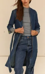 Trench de jean elastizado azul con cierre delantero, frunce en la cintura y lazo para atar.