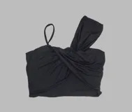 Top negro de algodón con diseño irregular, drapeado cruzado en el frente, un bretel fino en un lado y una manga corta ancha tipo caída en el otro.
