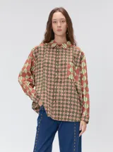 Camisa de manga larga con diseño estampado de rombos en tonos tierra, confeccionada en viscosa. Presenta cuello clásico, cierre frontal con botones, un bolsillo cuadrado en el pecho con logo bordado y puños a juego.