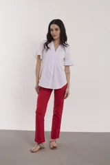 Camisa celeste con cuello mao, mangas cortas con volados y cierre frontal con botones.