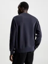 Buzo azul marino de algodón y poliéster con cuello redondo, puños y bajo acanalados. Presenta el logo de Calvin Klein bordado en pequeño en el pecho.
