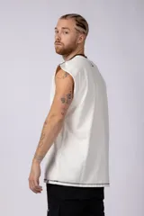 Musculosa oversize de algodón estilo sudadera, color crudo, con costuras visibles en contraste en color negro que recorren el centro verticalmente y enmarcan el cuello y el ruedo.